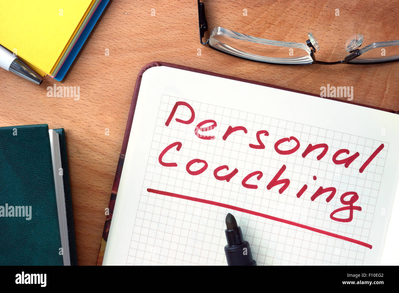 Notepad with Personal coaching on office wooden table. Stock Photo