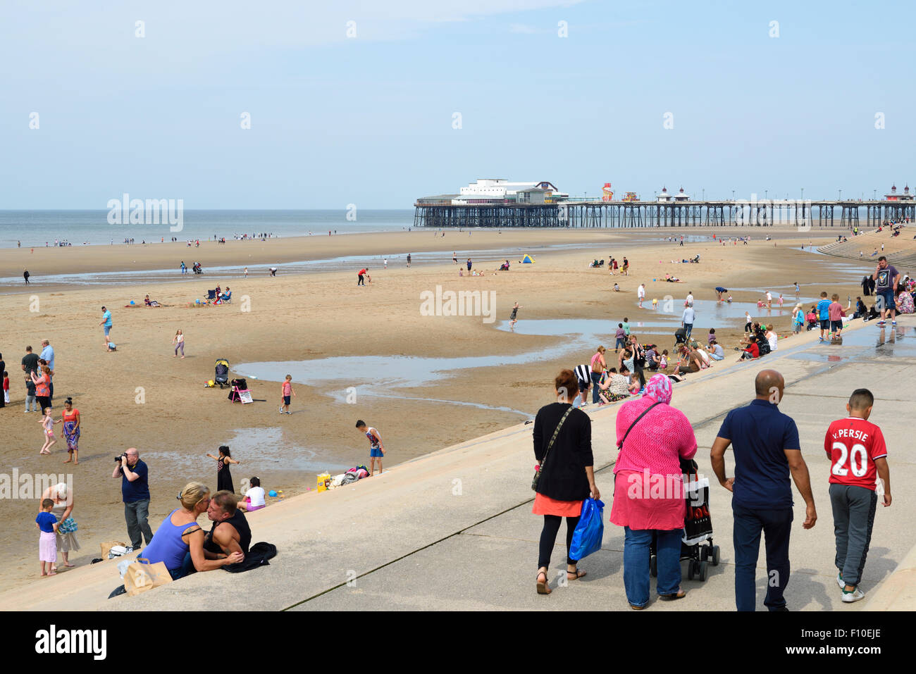 Holidaymakers on the sandy beach in front of Blackpool's North Pier Stock Photo