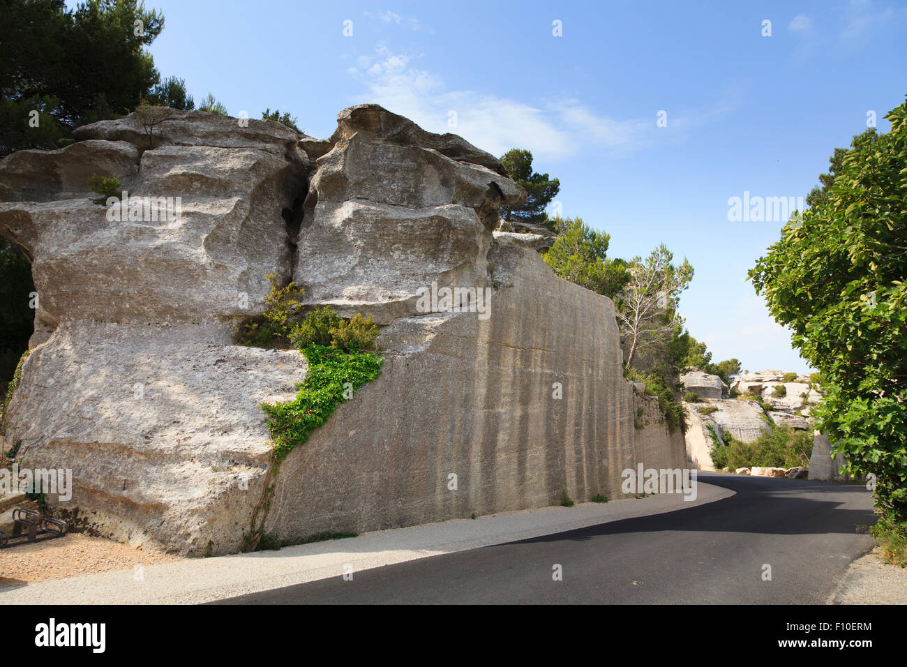 Road without cars cut through rocky hillside Stock Photo