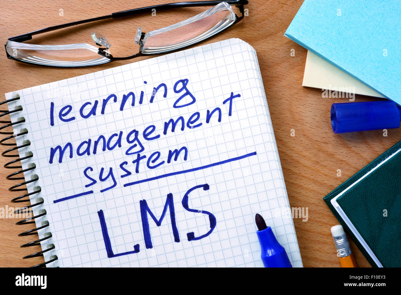 Notepad with learning management system LMS on office wooden table. Stock Photo