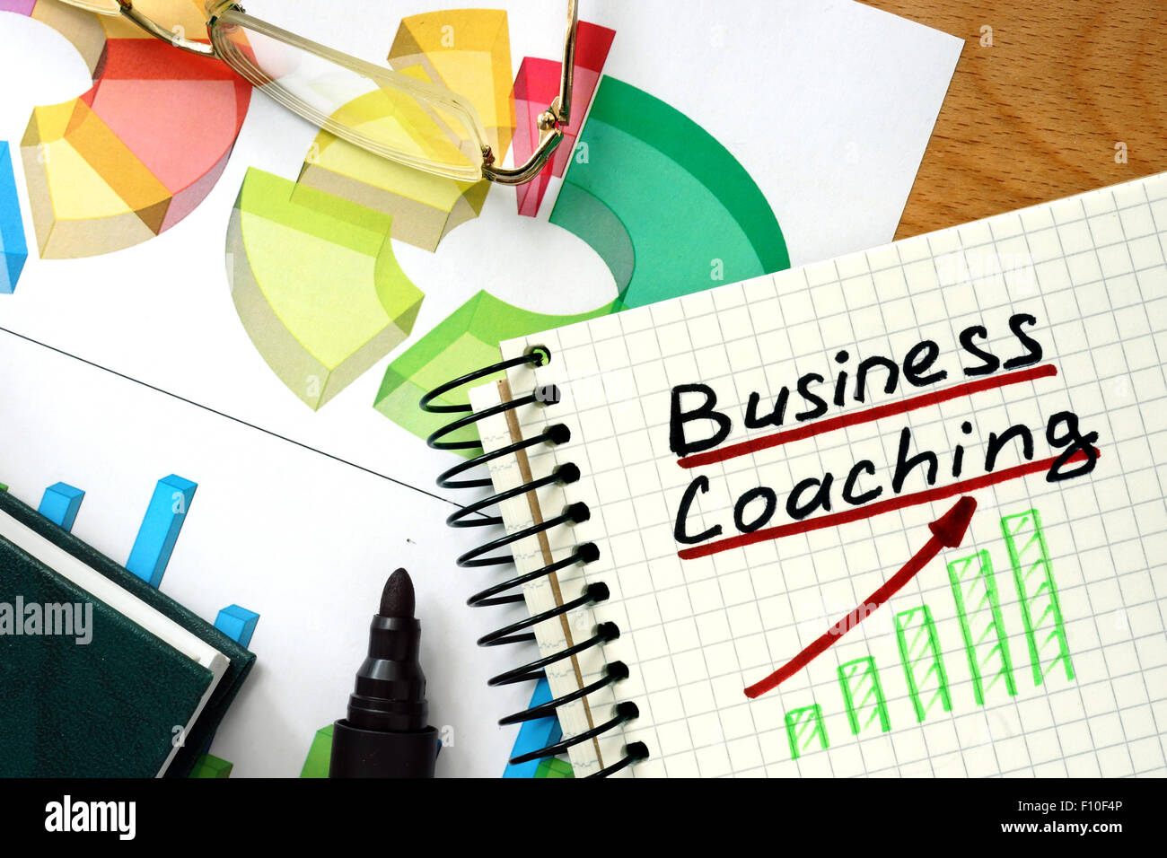 Note with words business coaching  on a wooden background. Stock Photo