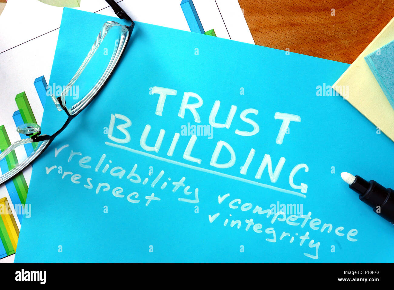 Blue paper with word trust building and glasses. Stock Photo