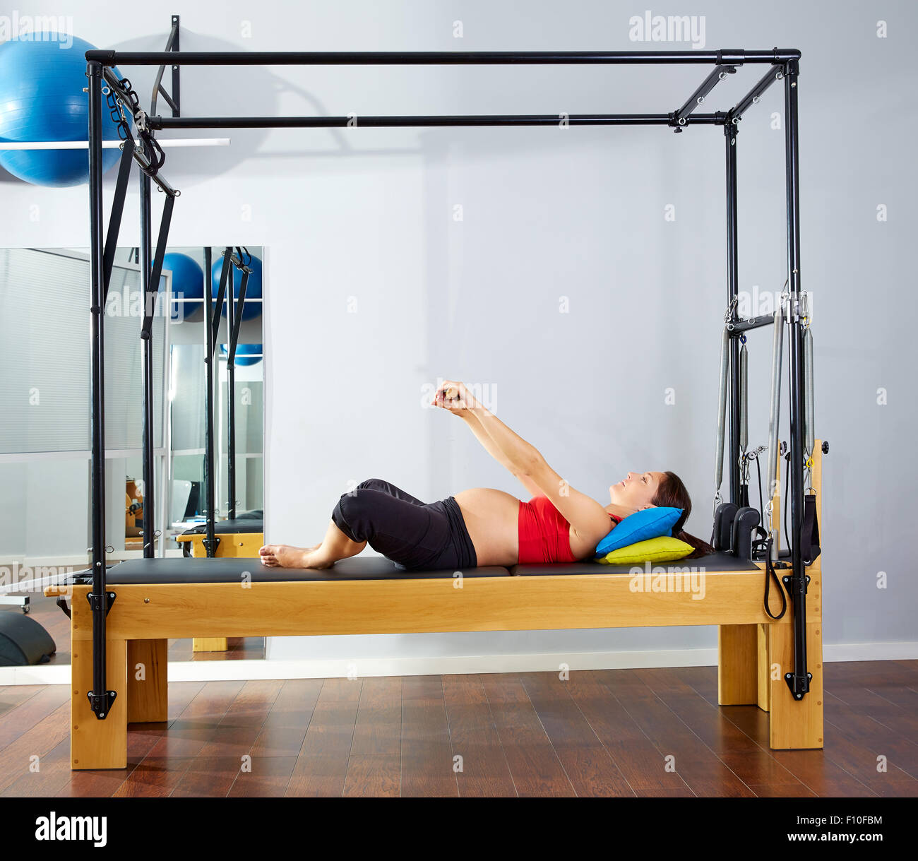 pregnant woman pilates reformer cadillac exercise workout at gym Stock