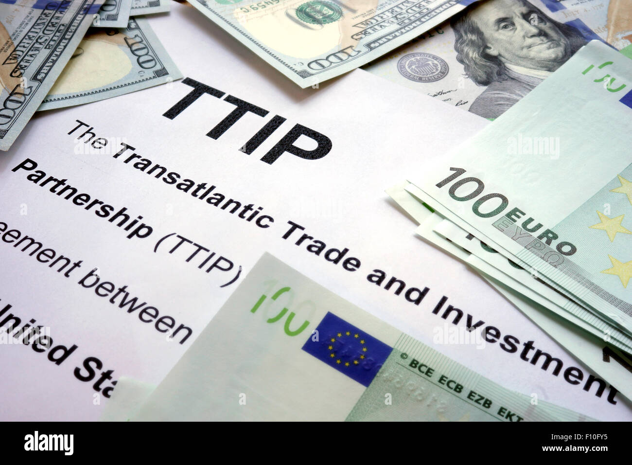 Word TTIP on a paper with dollars and euros. Stock Photo