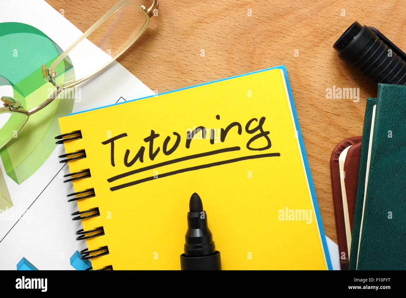 Notepad with tutoring on a wooden table. Stock Photo