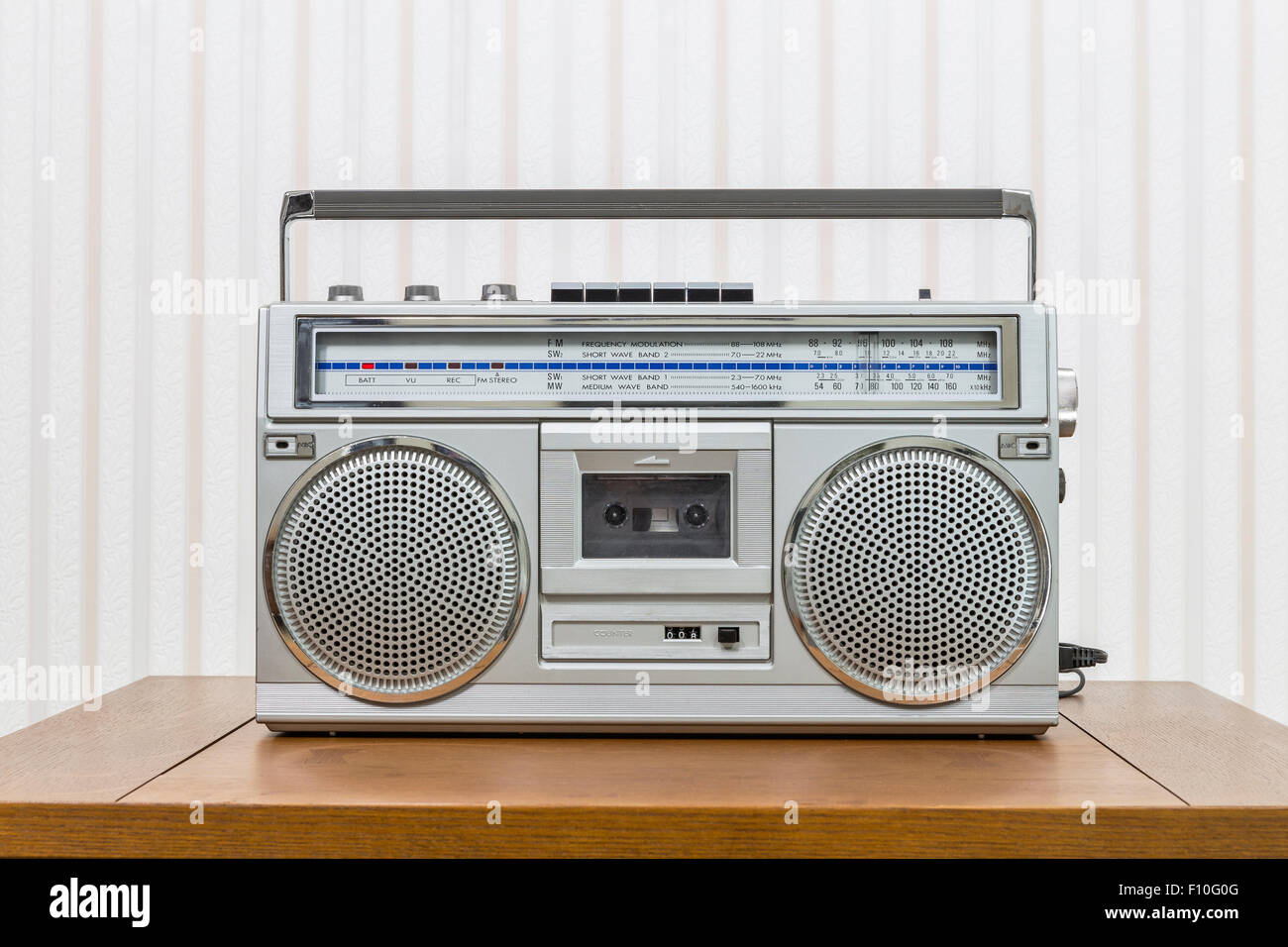 Vintage portable boom box style radio cassette player on old wood table. Stock Photo
