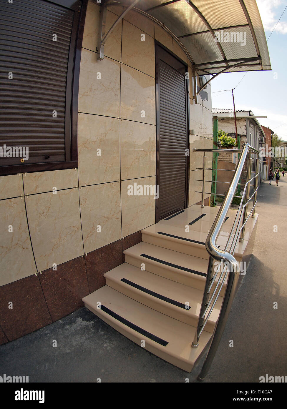 The facade of an apartment house with a porch and the door with wide