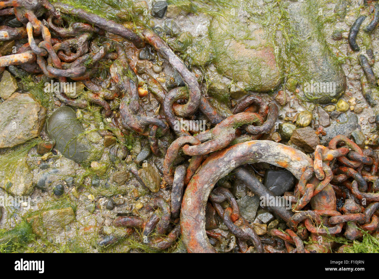 Old rusty chain mooring point o seashore. UK Stock Photo