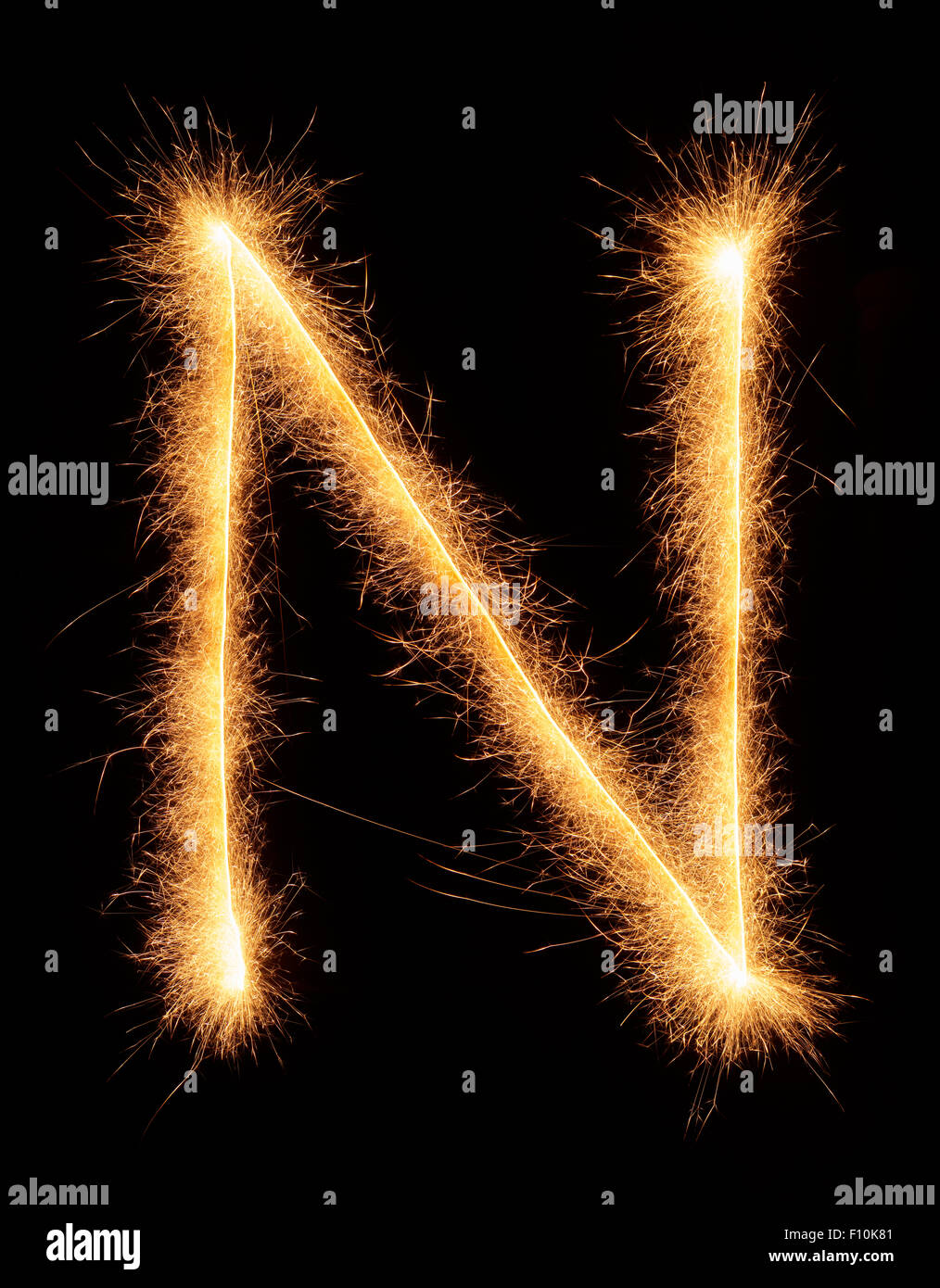 'N' letter drawn with bengali sparkles isolated on black background Stock Photo