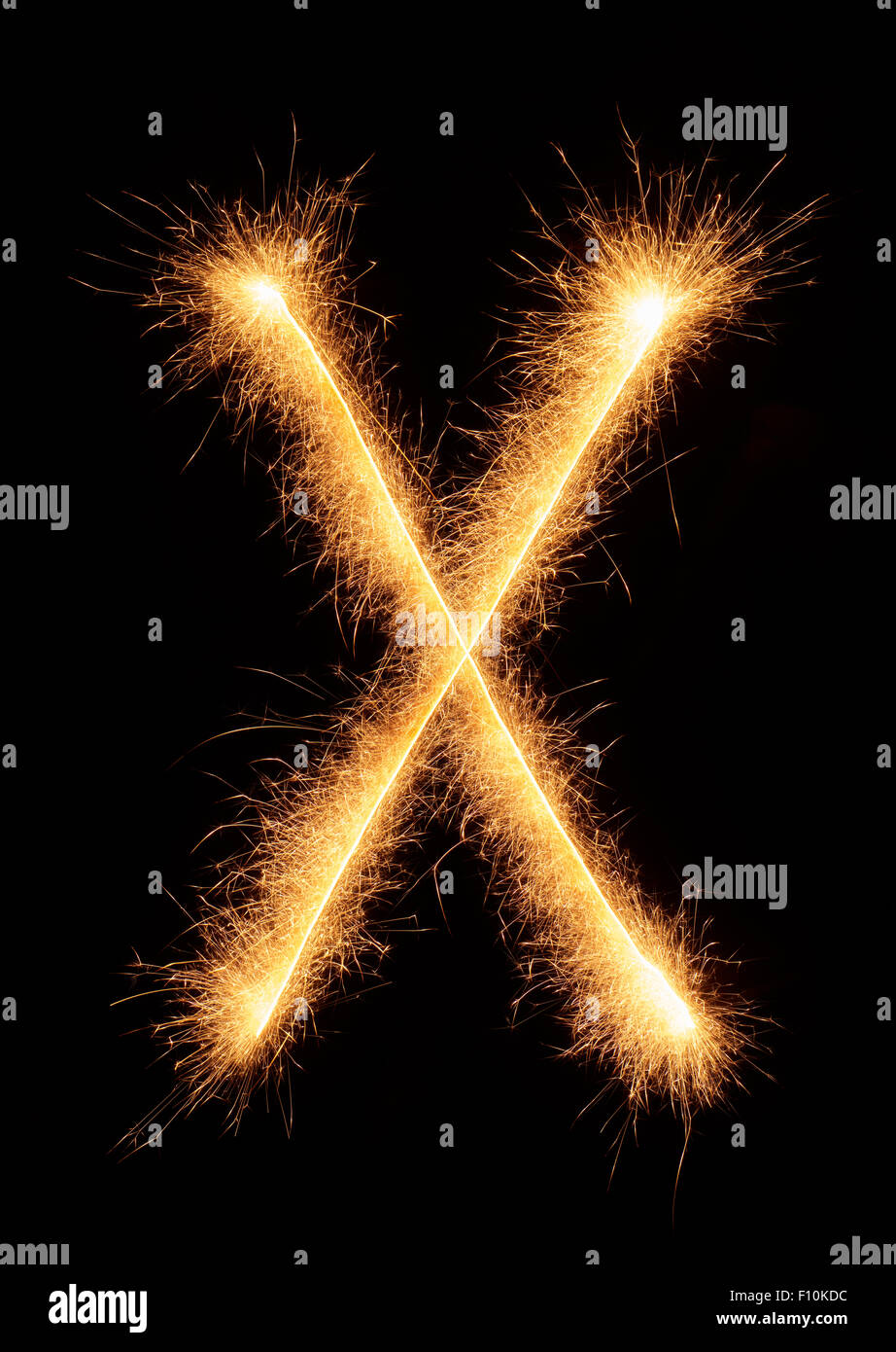'X' letter drawn with bengali sparkles isolated on black background Stock Photo