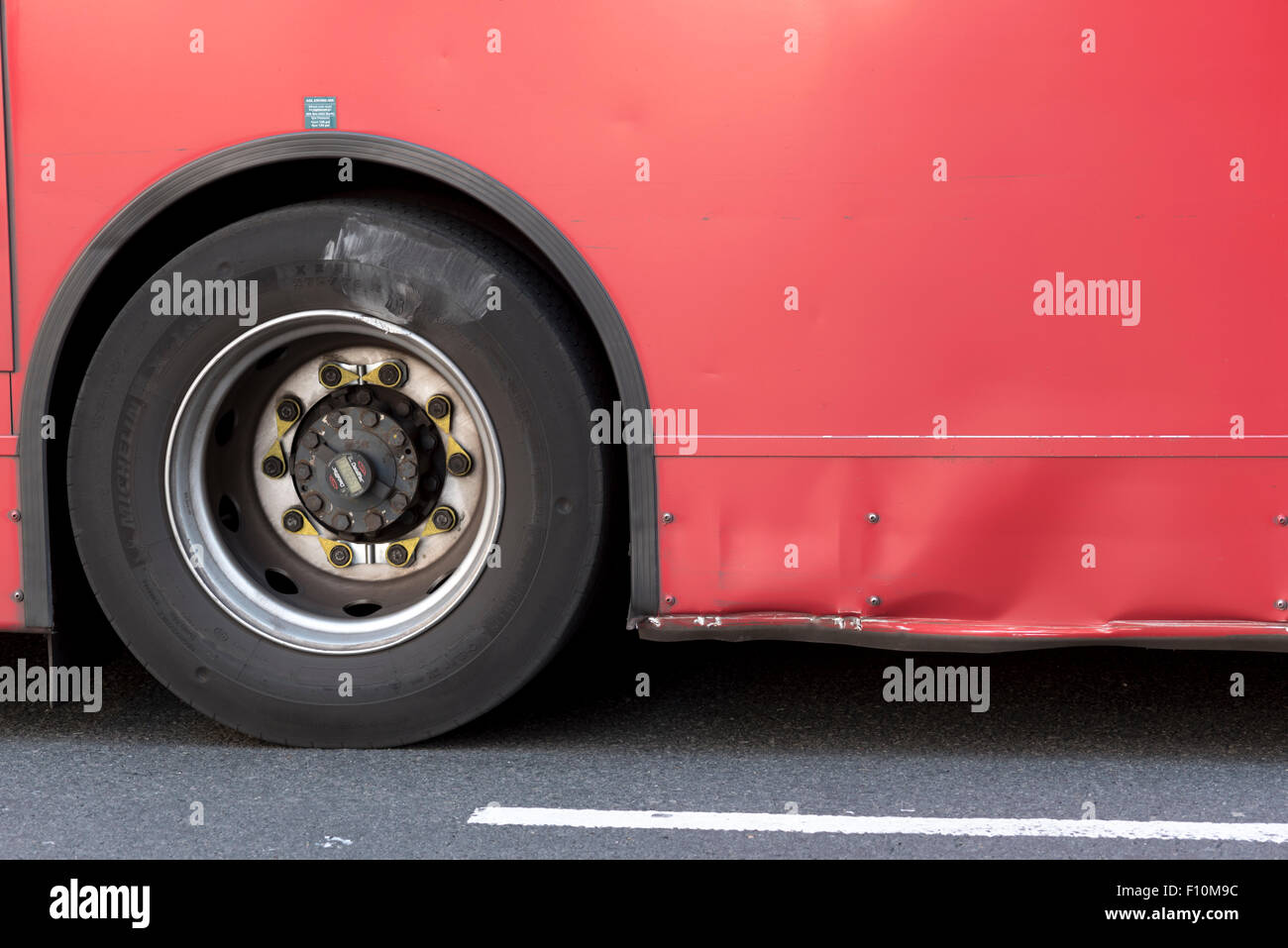 A close up view of the wheel of a red London Transport bus Stock Photo