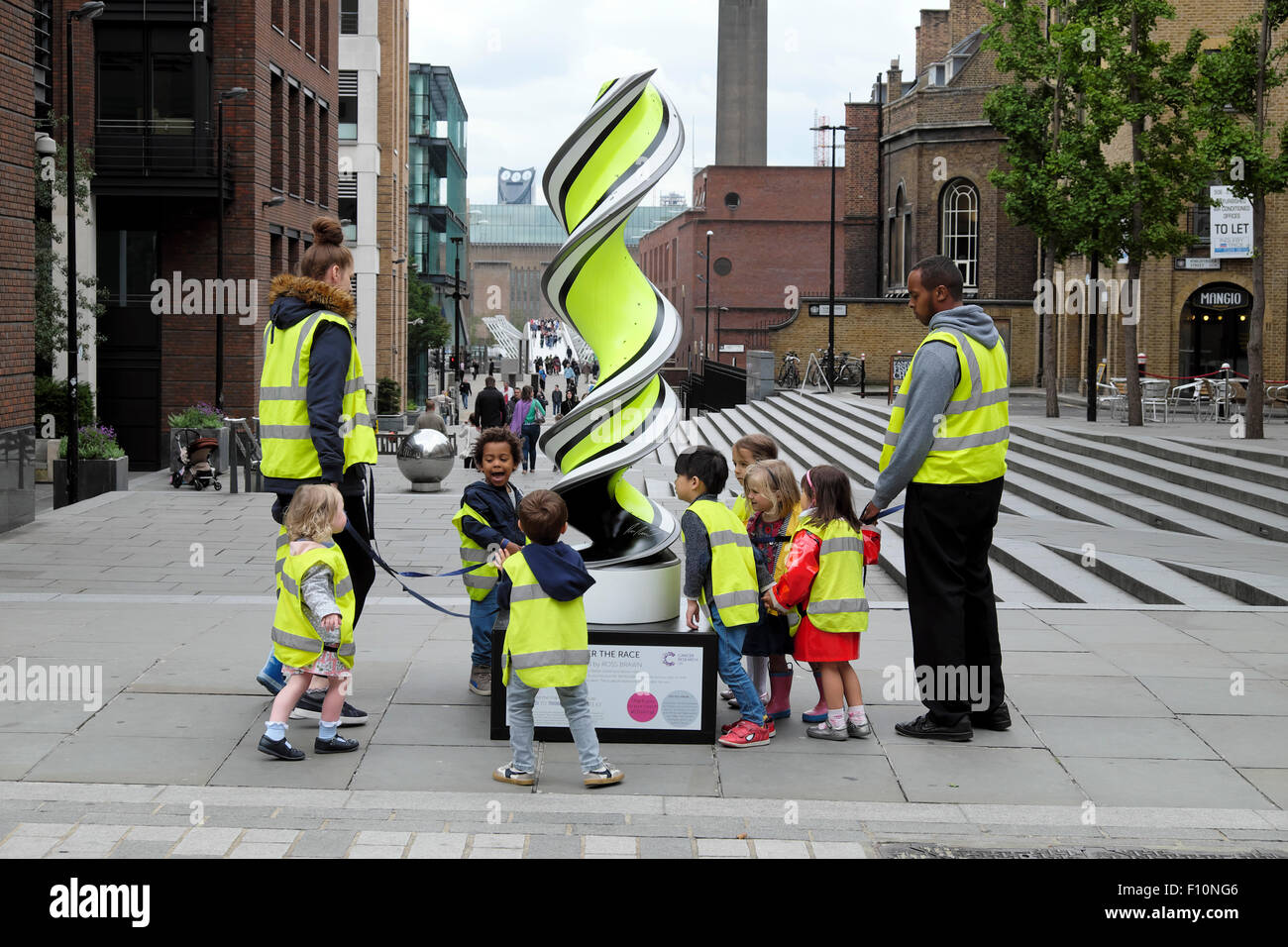 Nursery school age children with childminders wearing high visibility