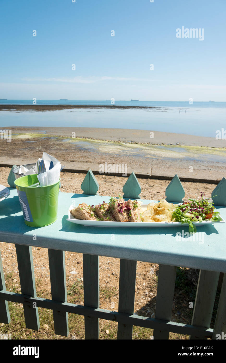 A view across the bay at low tide from a table at the Beach Hut cafe and restauarant on the beach at Bembridge Isle of Wight Stock Photo