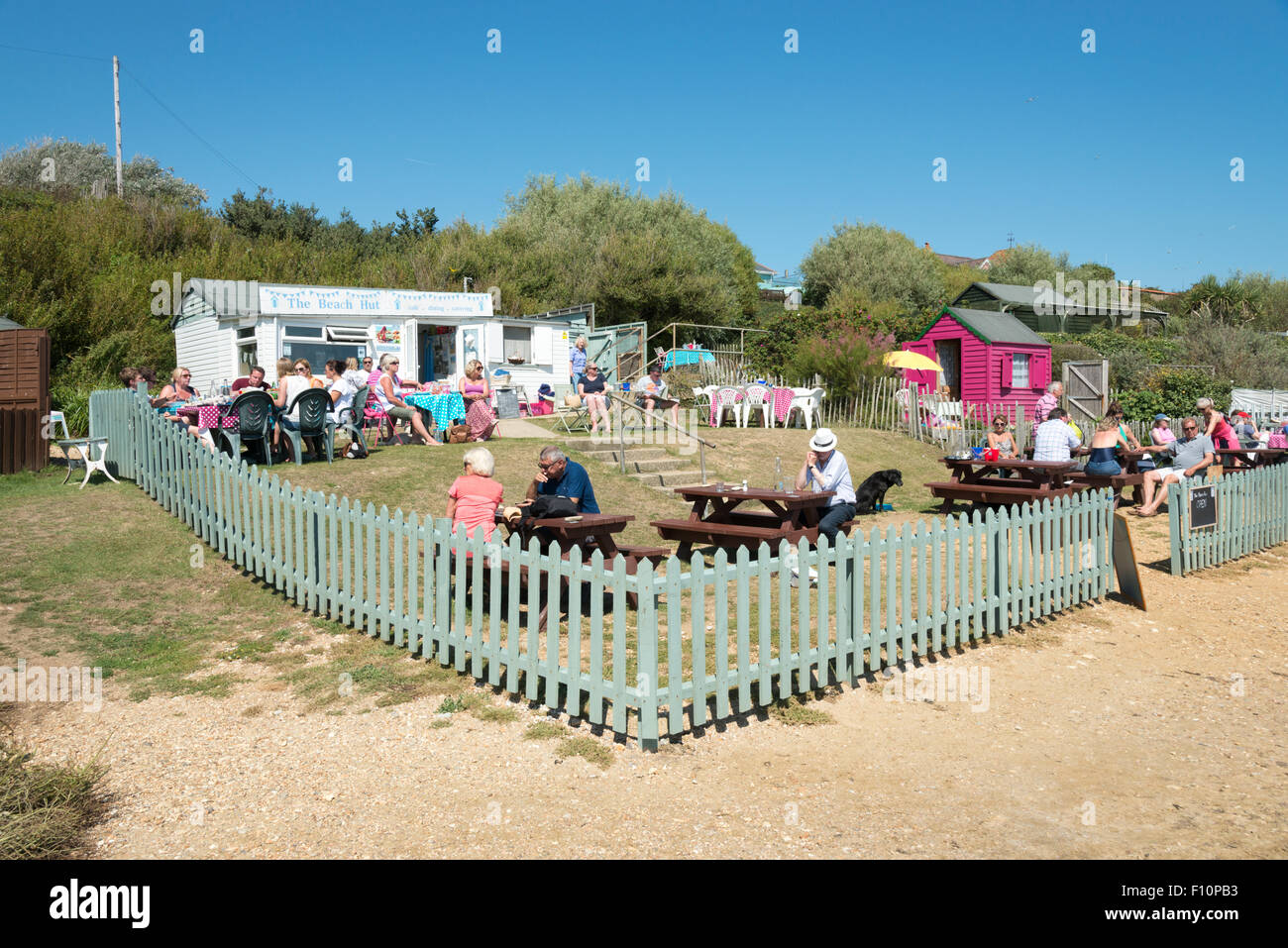 Diners eating outside at the Beach Hut cafe and restaurant on the coast at Bembridge Isle of Wight UK Stock Photo