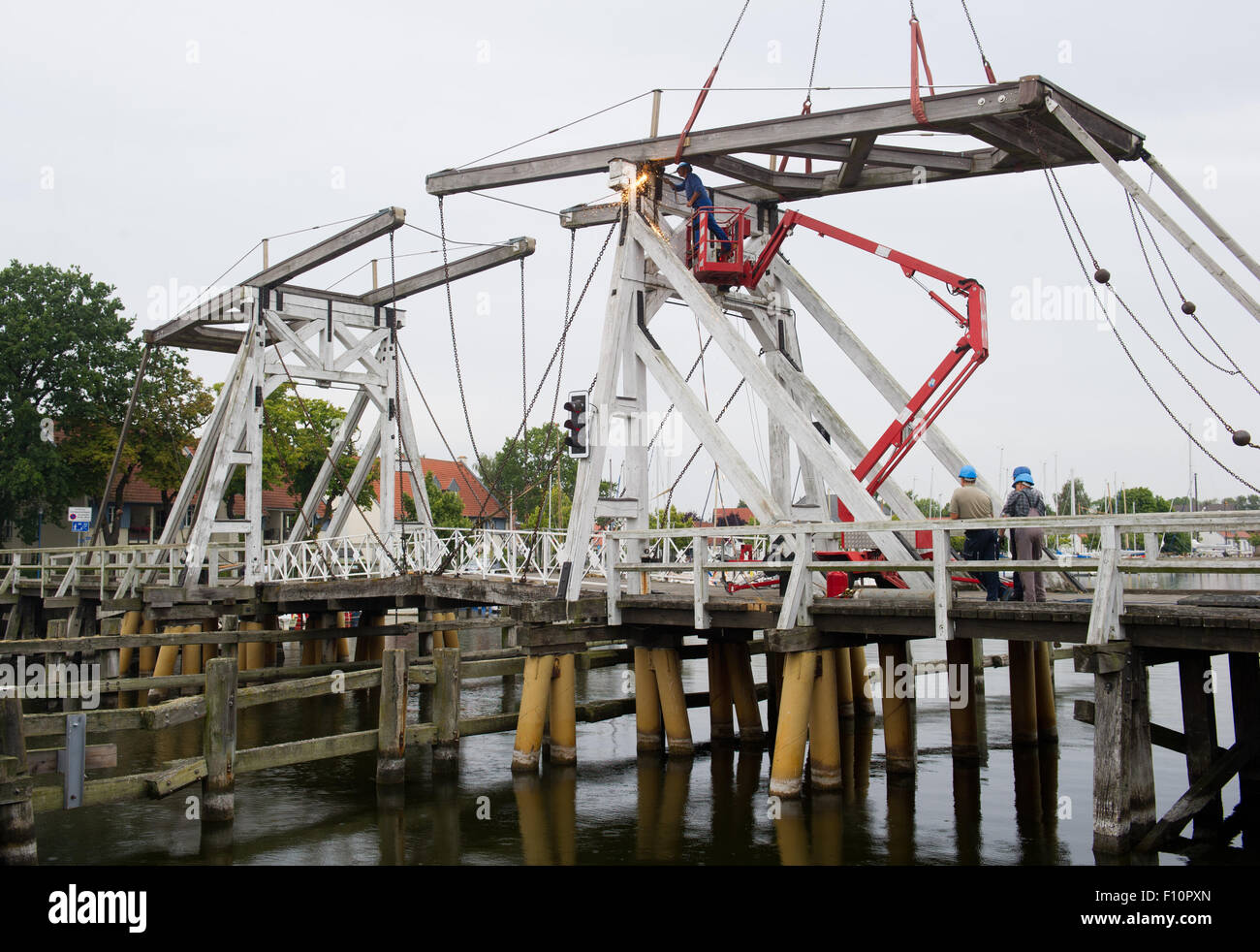 Greifswald-Wieck, Germany. 24th Aug, 2015. A balance beam of the broken bridge 'Klappbruecke' is dismantled by experts in Greifswald-Wieck, Germany, 24 August 2015. Several parts of the 128 year-old wooden bridge need to be rebuild due to fungal infestation. PHOTO: STEFAN SAUER/dpa/Alamy Live News Stock Photo