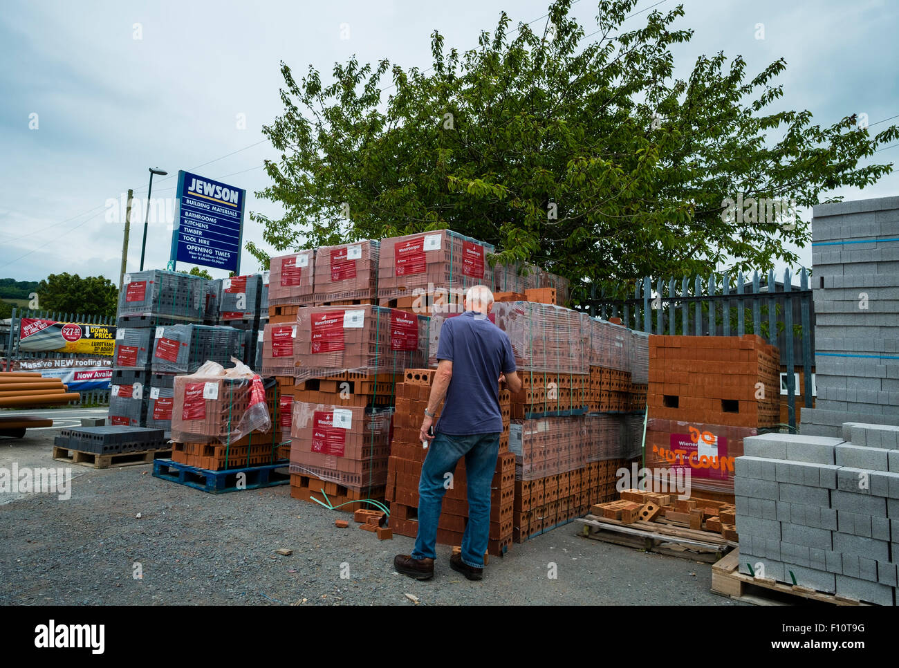 A customer looking at stacks of bricks at a branch of Jewson builders