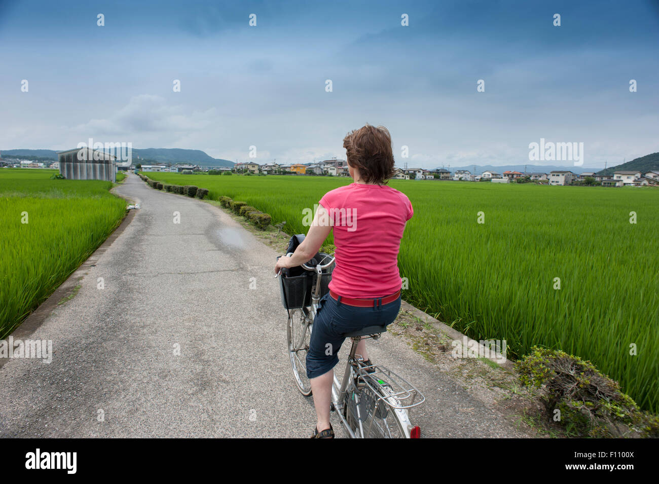 A mature woman enjoying cycling along the Kibi Bike Trail in Japan. Stock Photo