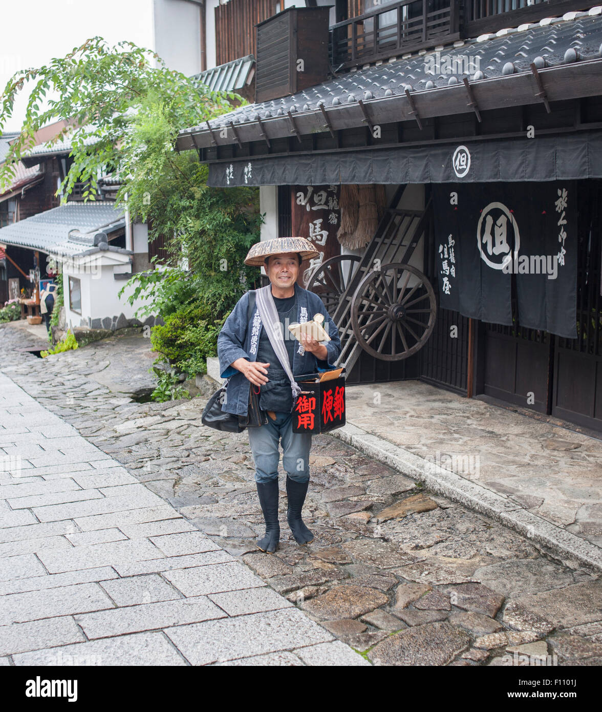 Traditionally dressed Japanese postman delivering the mail, Nakasendo Way, Japan. Stock Photo