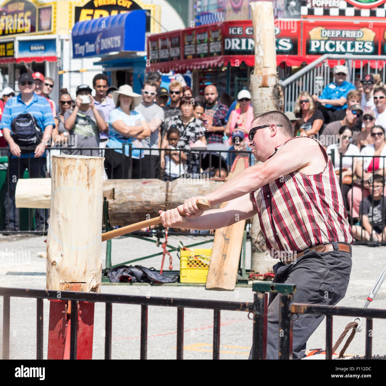 Lumberjack with axe chopping a log in a lumberjack logging competition at the Canadian National Exhibition in Toronto, Ontario, Stock Photo