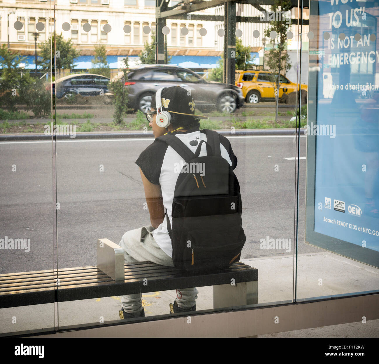 A man wears his Beats by Dr. Dre headphones as he waits for a bus in New York on Saturday,  August 22, 2015.  (© Richard B. Levine) Stock Photo