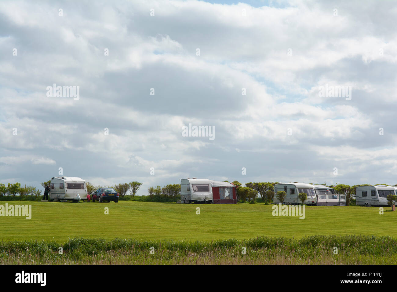 Caravan with Awnings and Motorhome in a field at Fraisethorpe Beach