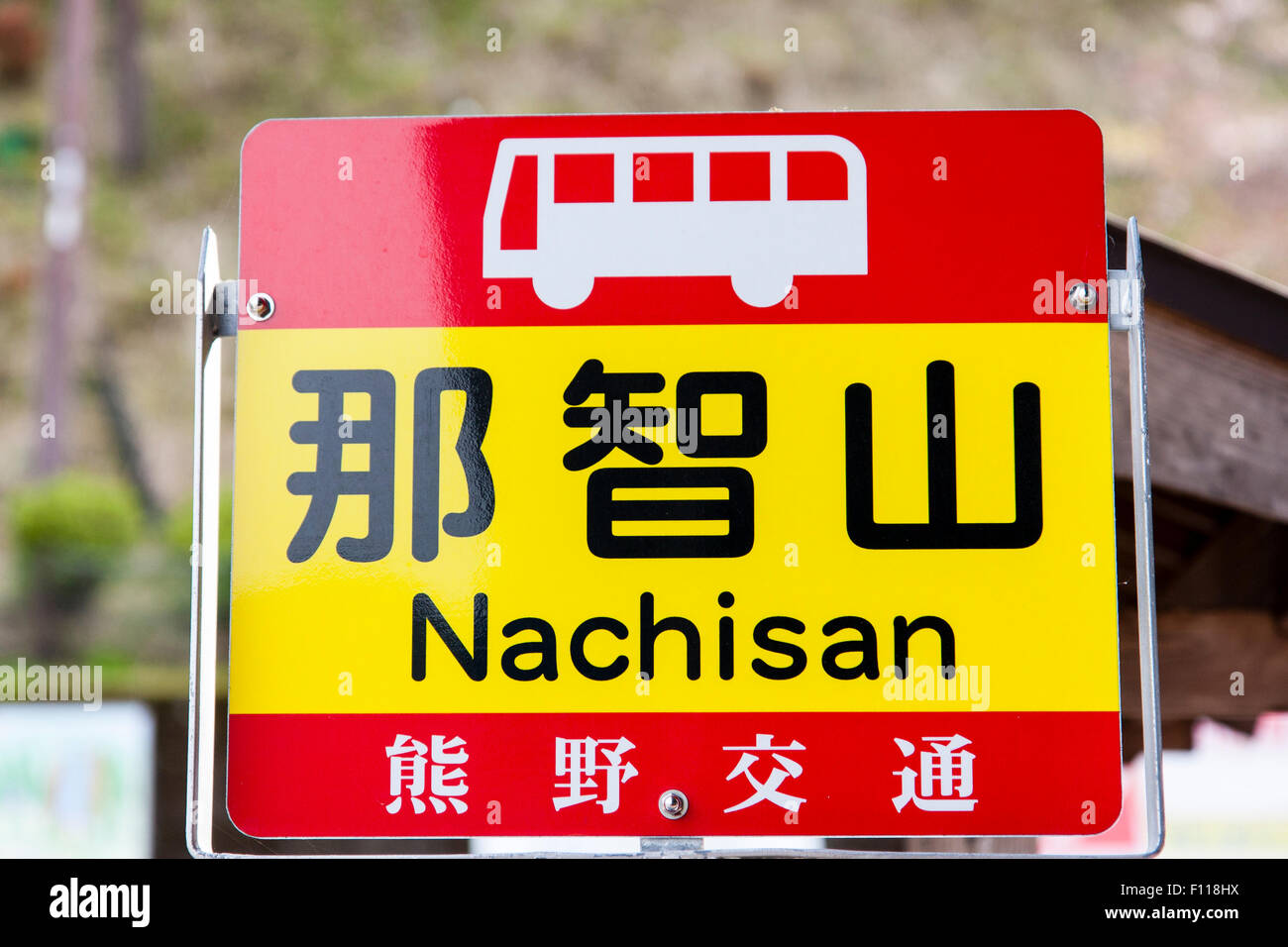 Japan, Nachikatsuura. Red and yellow bus stop sign at Nachi no taki waterfalls for bus to Nachisan. Stock Photo