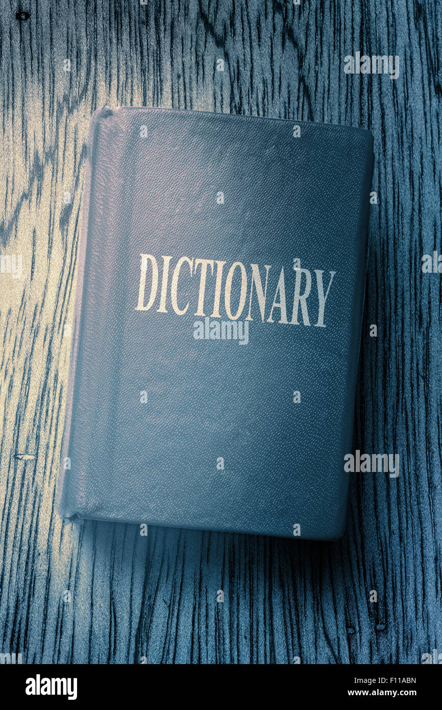 Old blue dictionary on wooden textured background Stock Photo