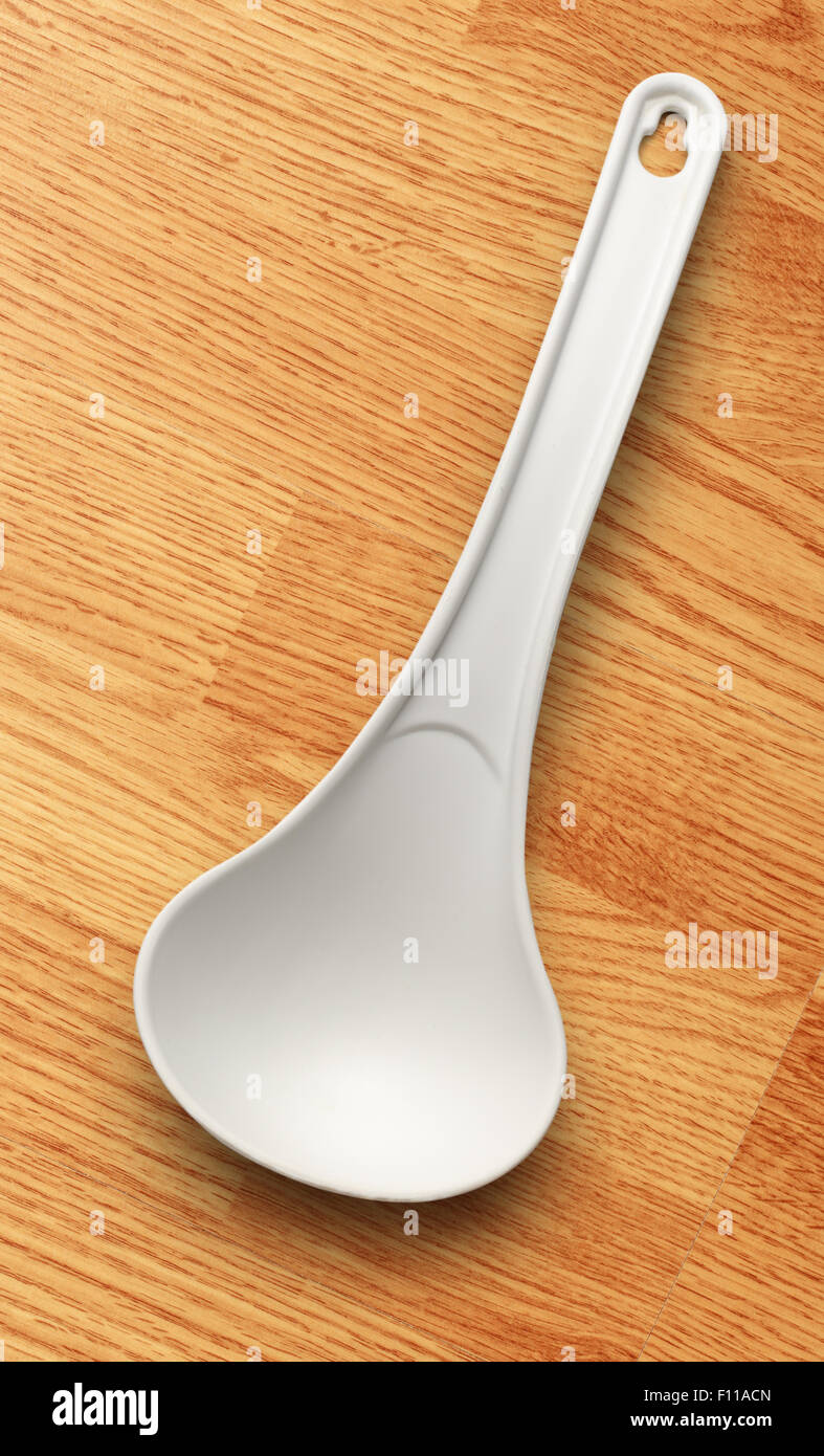 White plastic ladle on the wooden background Stock Photo