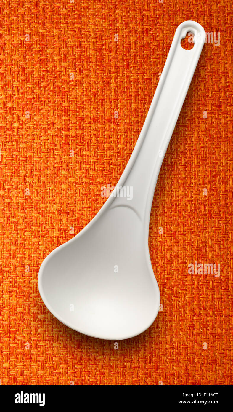 White plastic ladle on the cloth background Stock Photo