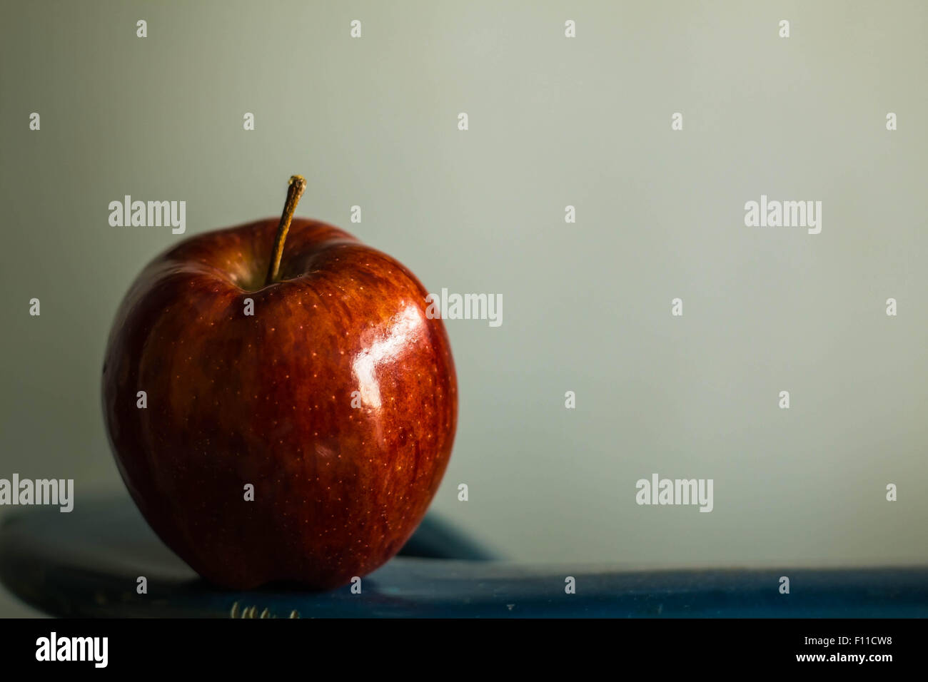 red apple on a green background Stock Photo - Alamy