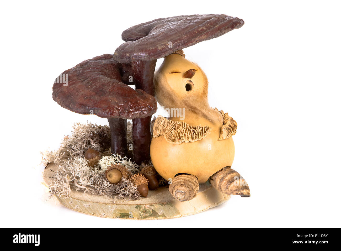 Handmade gnome of natural materials sleeping under fungi Stock Photo