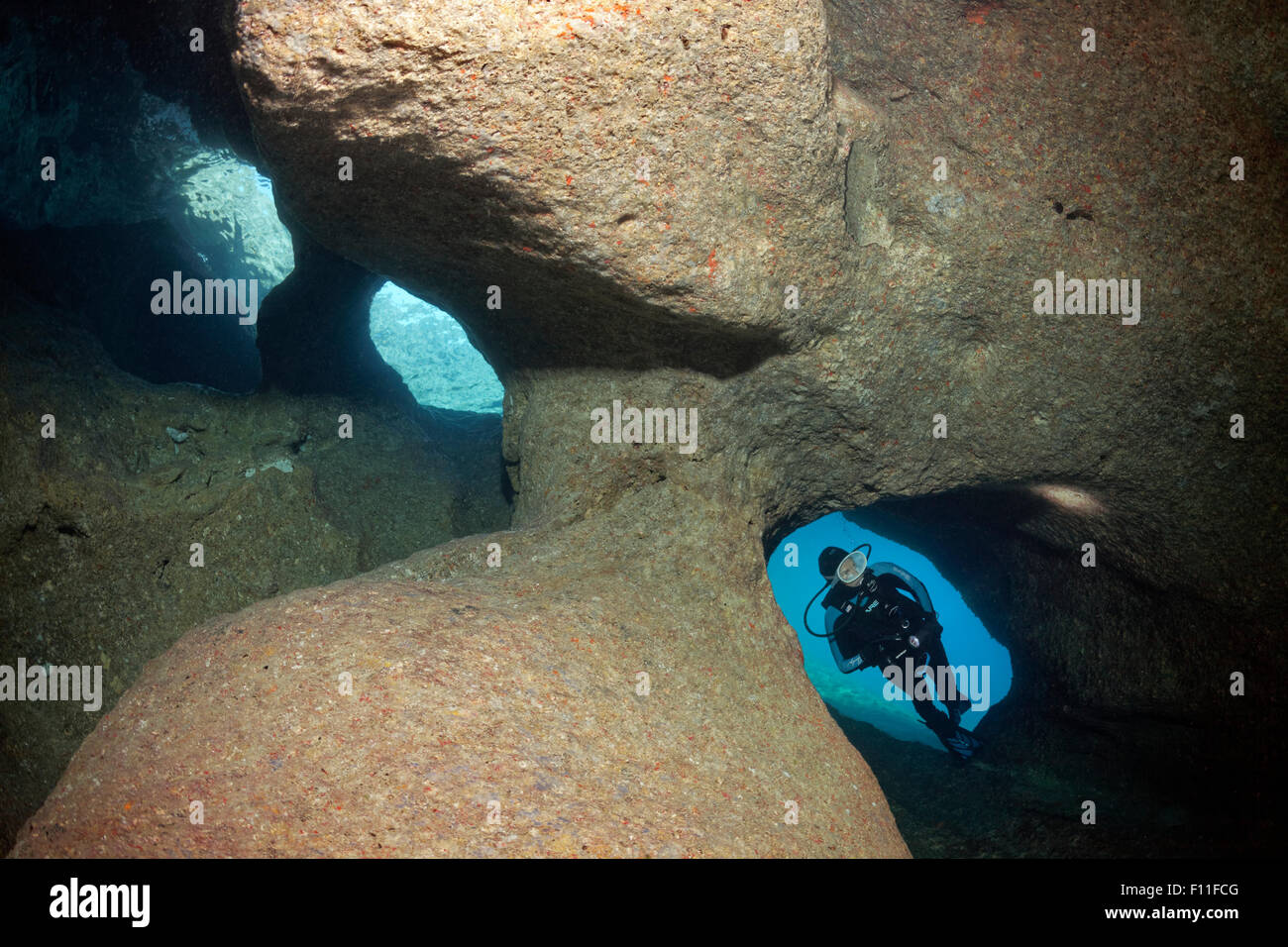 Diver exploring a cave with three entrances, island Corfu, Ionian Islands, Mediterranean Sea, Greece Stock Photo