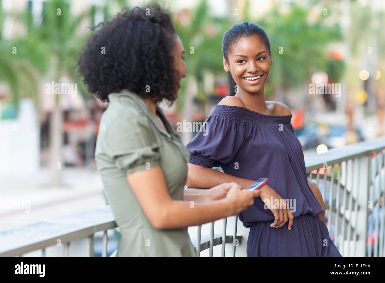 Black women talking on balcony Stock Photo