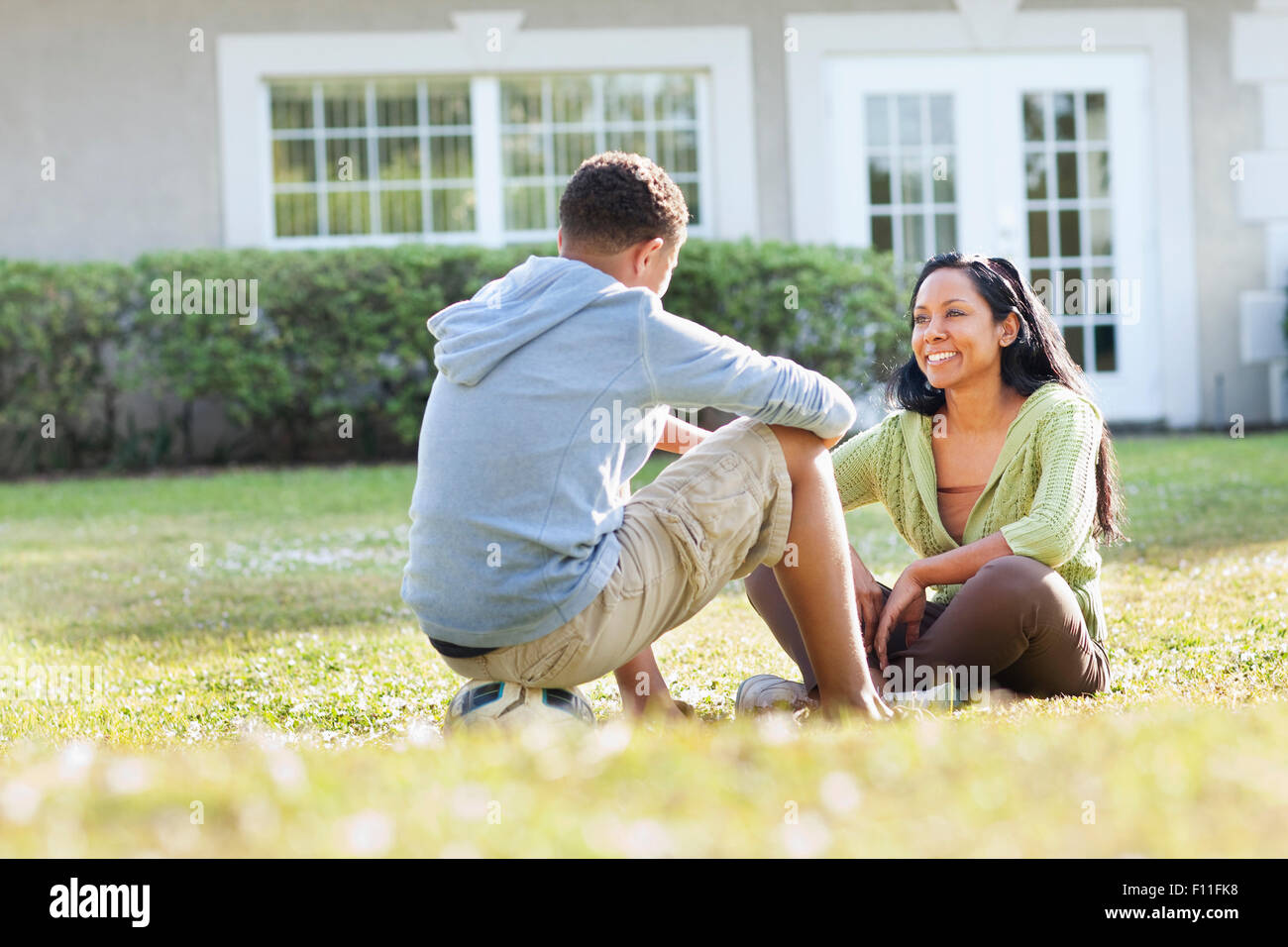 Mother and son talking in backyard Stock Photo