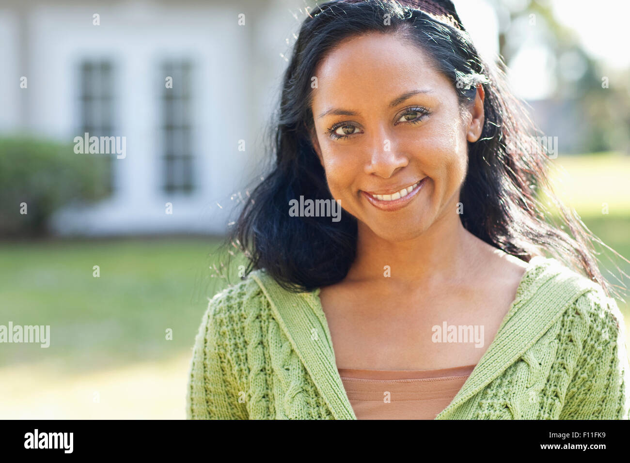 Indian woman smiling in backyard Stock Photo