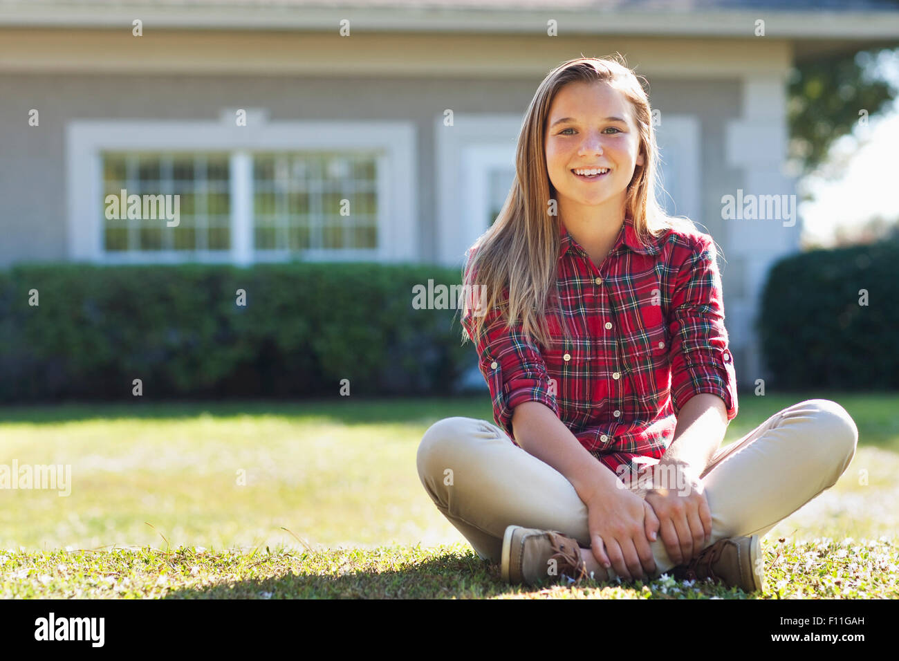 Caucasian girl sitting in backyard Stock Photo - Alamy