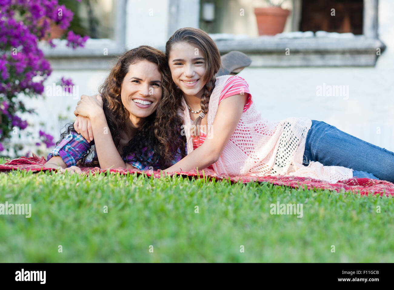 Hispanic mother and daughter hugging in backyard Stock Photo