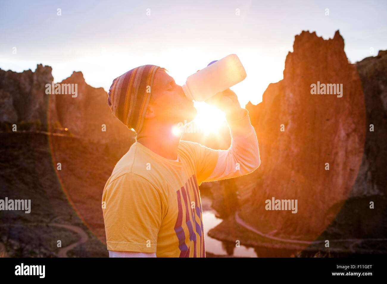 Caucasian man drinking water bottle in desert landscape, Smith Rock State Park, Oregon, United States Stock Photo