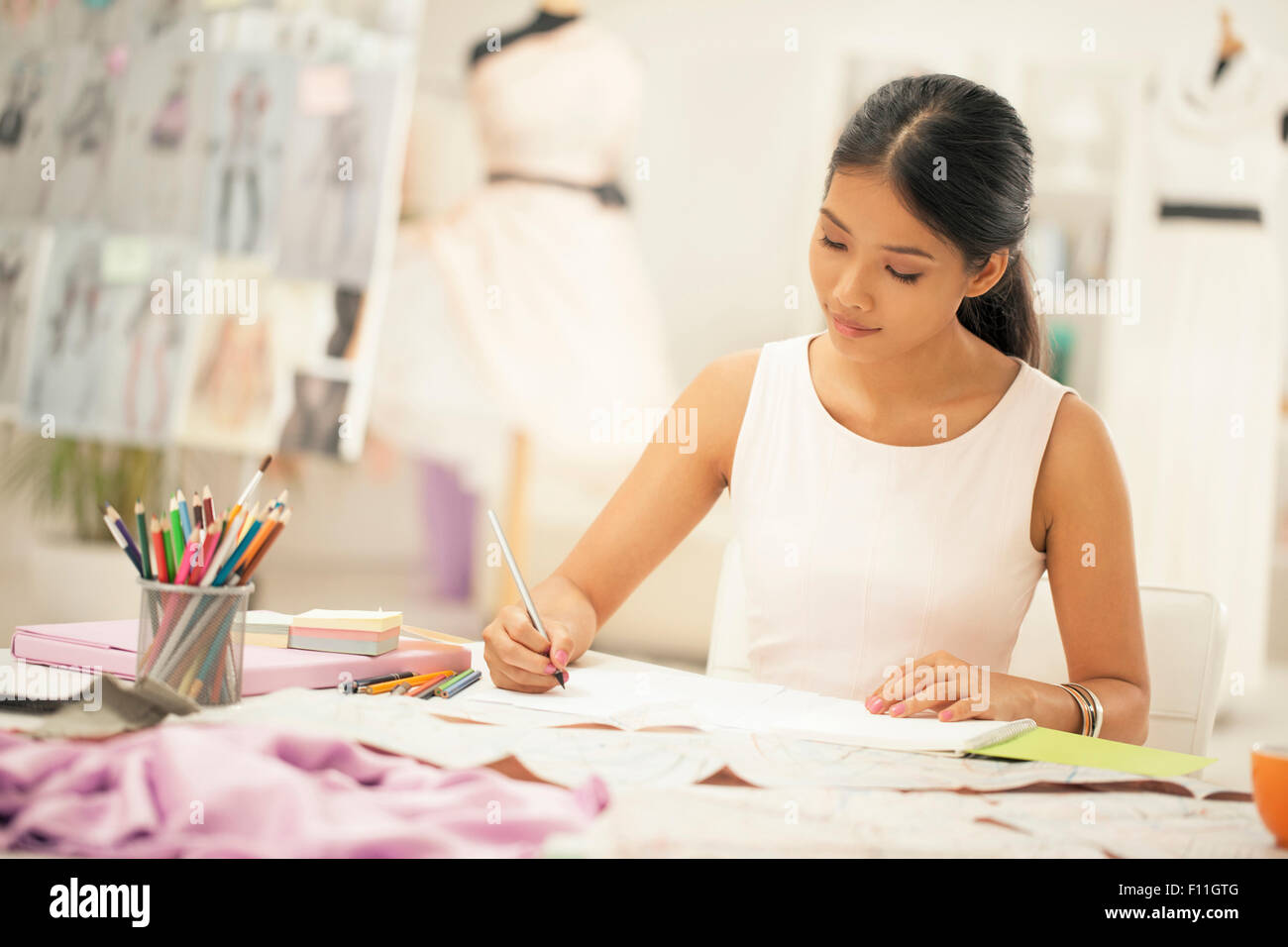 Fashion designer drawing in studio Stock Photo - Alamy