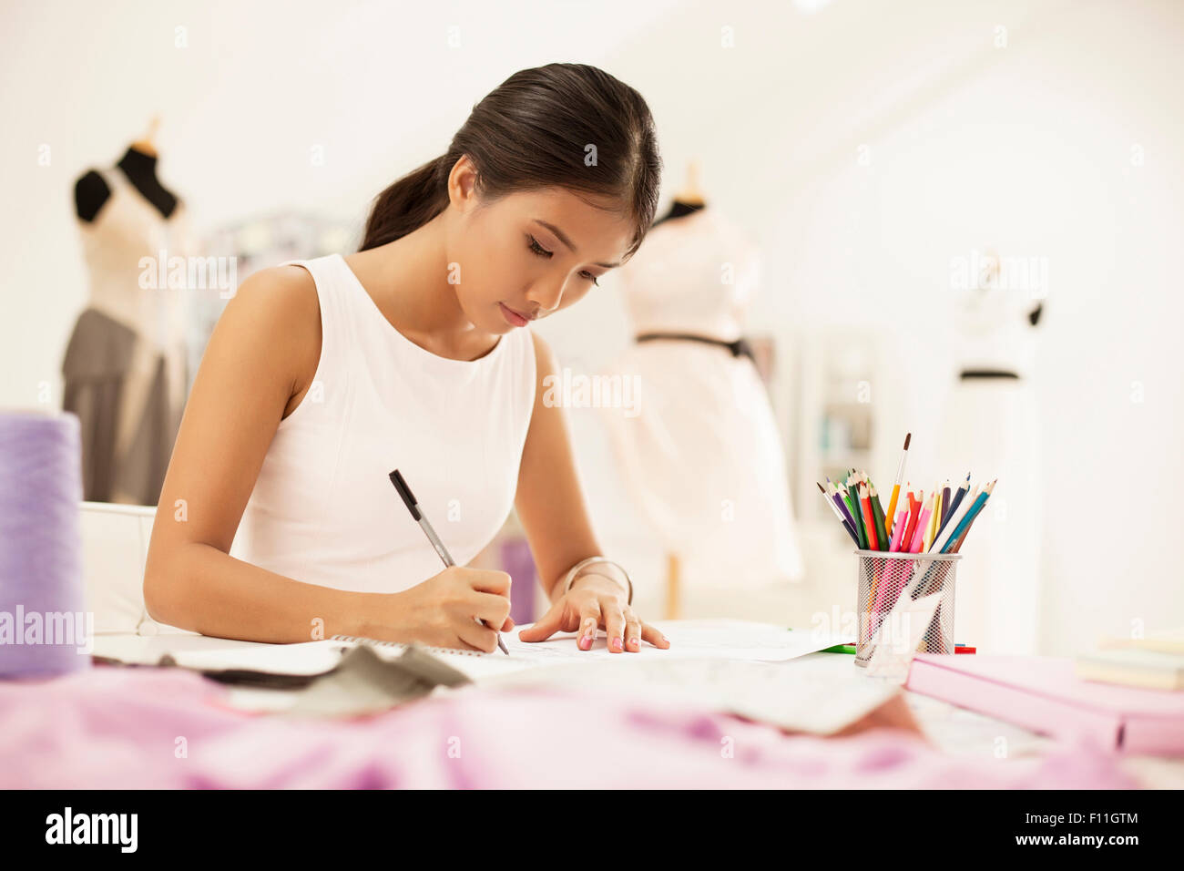 Fashion designer drawing in studio Stock Photo - Alamy
