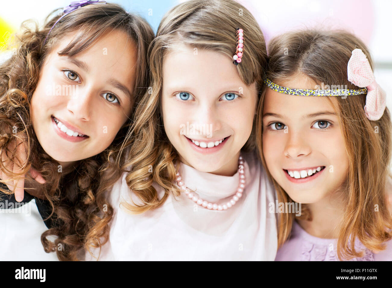Close up of smiling girls hugging Stock Photo - Alamy