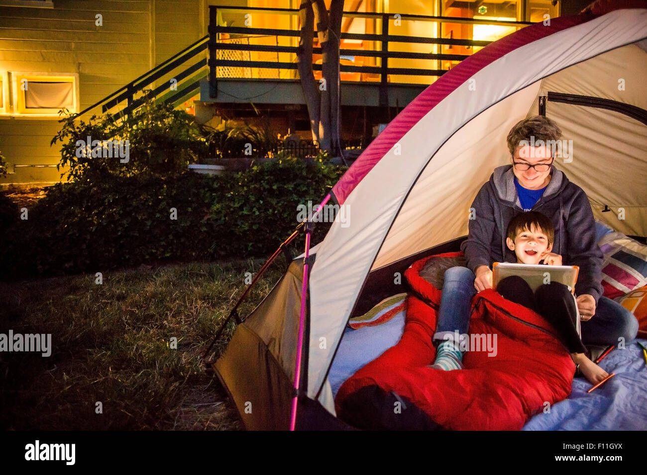 Mother and son using digital tablet in backyard tent Stock Photo