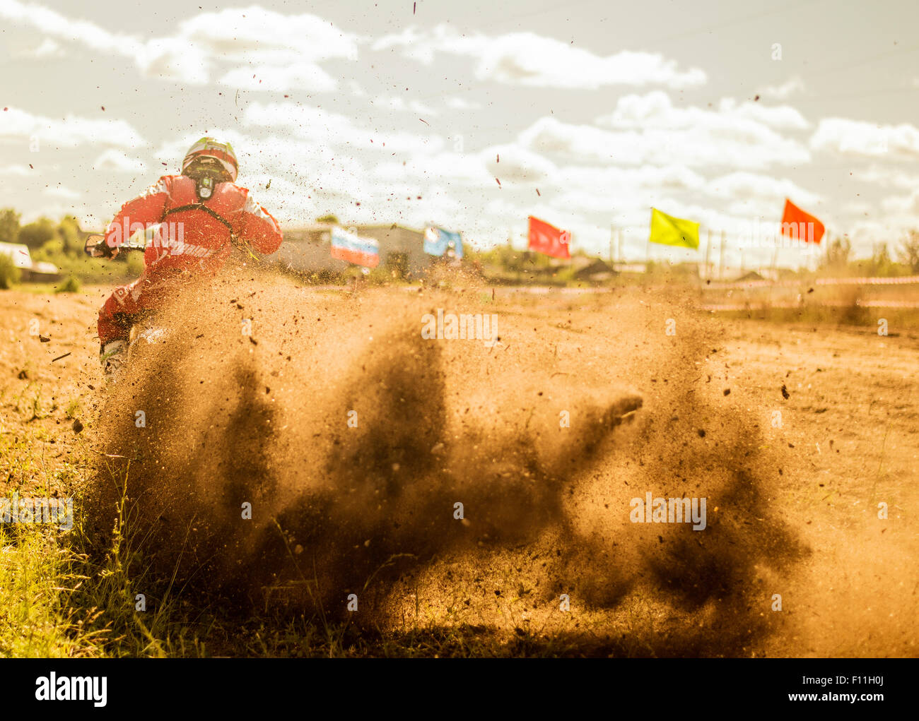 Caucasian motocross biker spraying dirt on race course Stock Photo