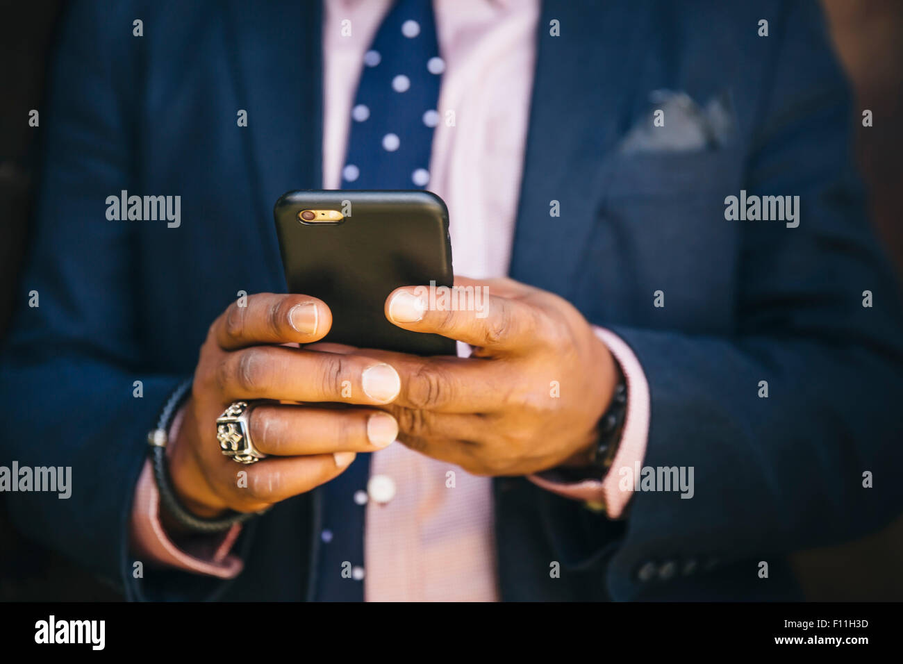 Close up of mixed race businessman using cell phone Stock Photo
