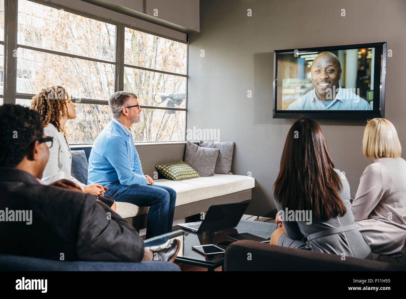 Business people watching teleconference in office meeting Stock Photo