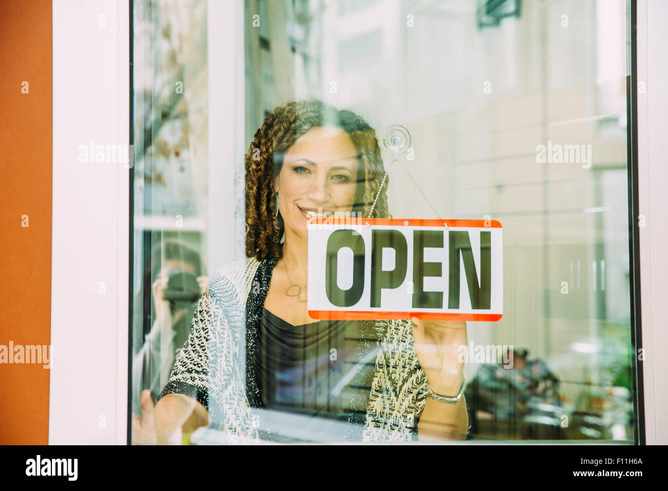 Mixed race store owner opening door Stock Photo Alamy