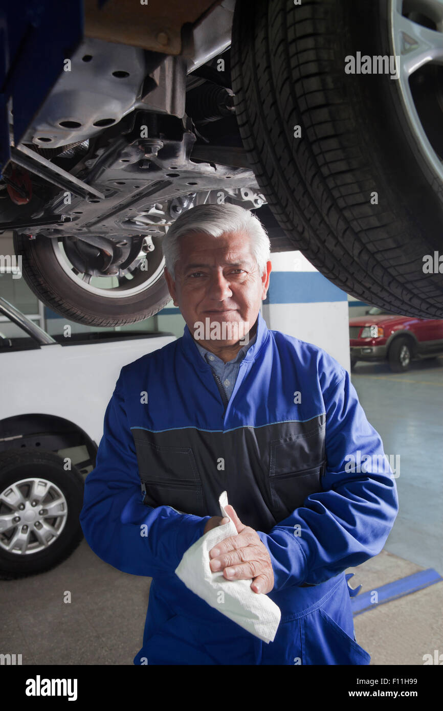Older Hispanic mechanic working in garage Stock Photo