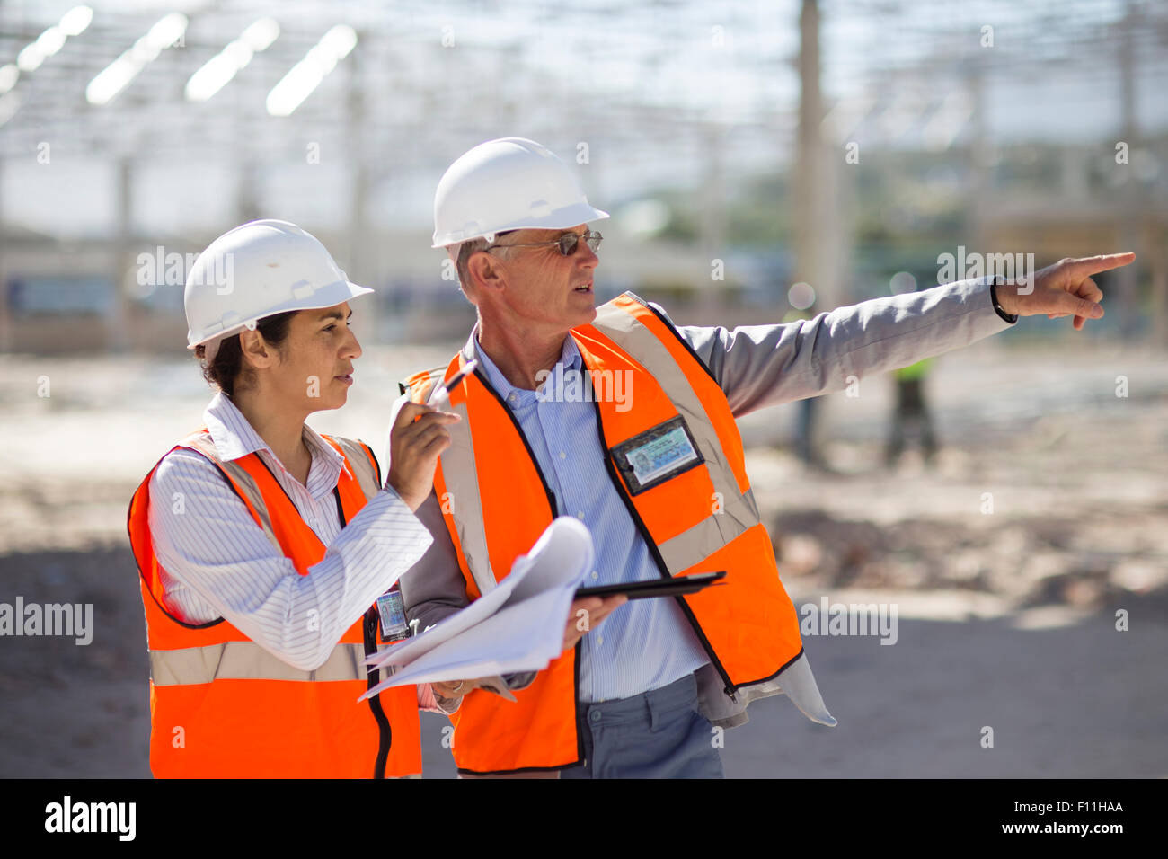 Architects reading blueprints at construction site Stock Photo