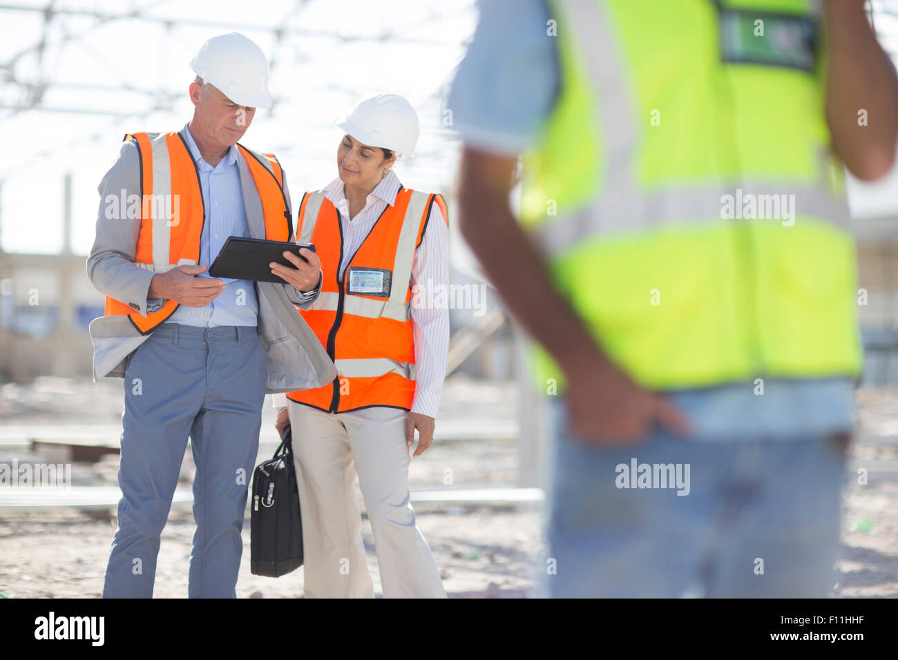 Architects using digital tablet at construction site Stock Photo