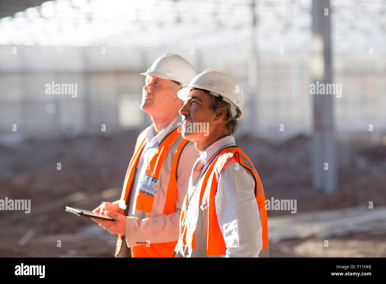 Caucasian architects using digital tablet at construction site Stock Photo